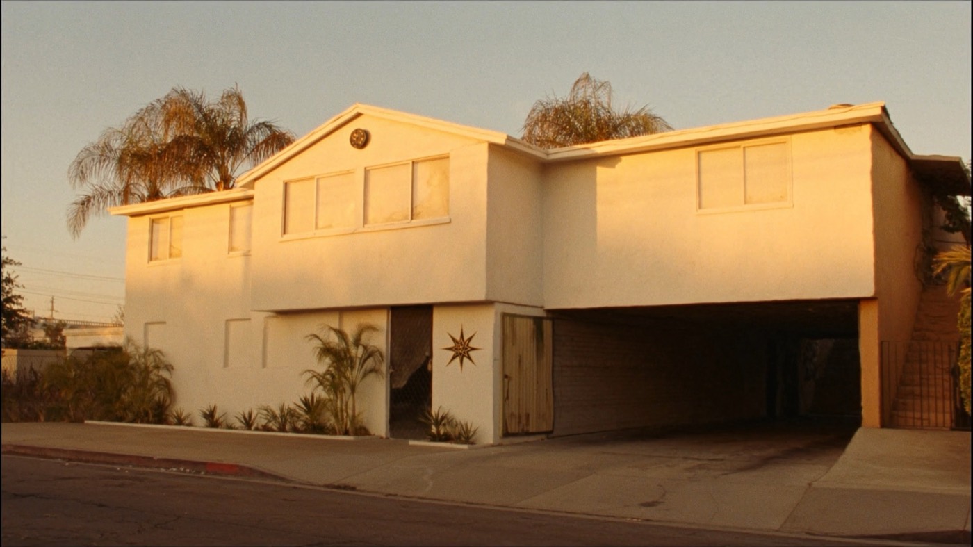A 1960s Los Angeles dingbat apartment building, its stucco lit gold by the late afternoon sun.