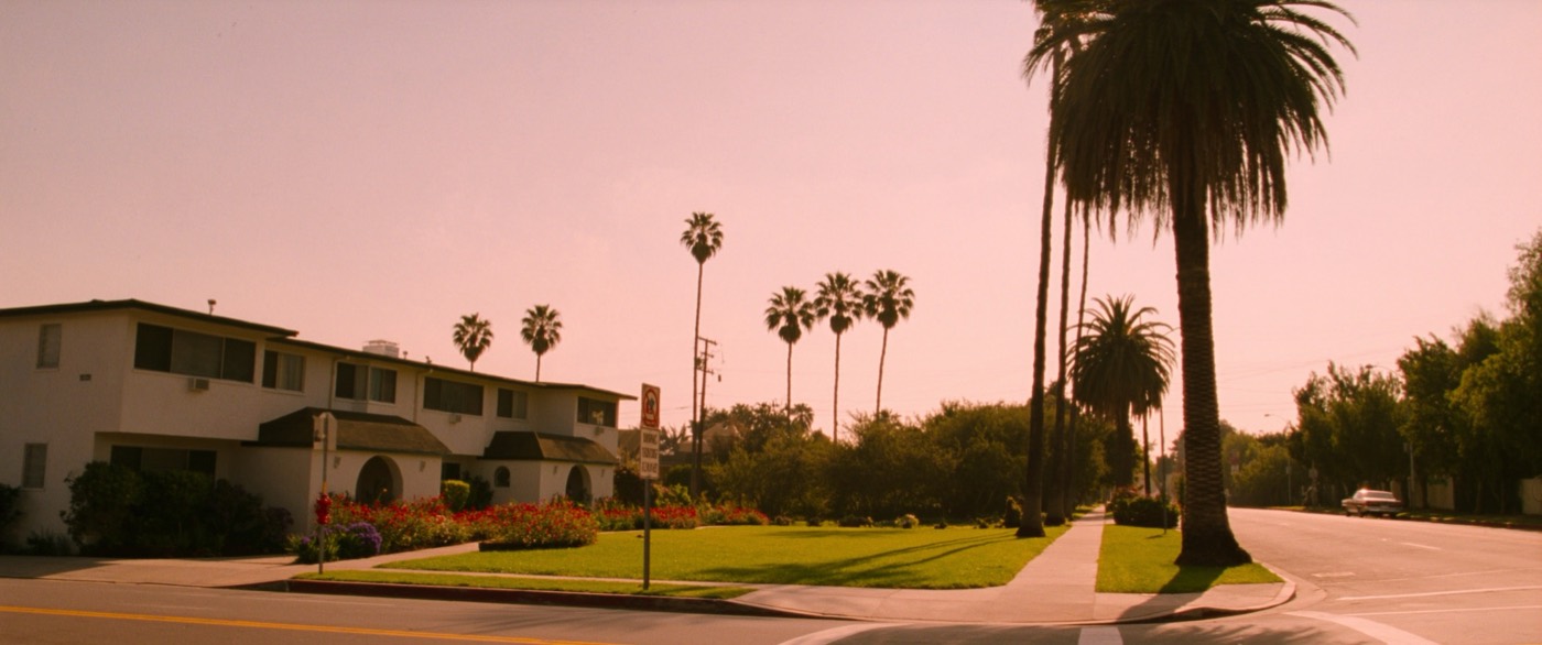 A Los Angeles residential street of low apartment buildings in late afternoon light.